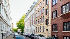 A row of parked cars along a street lined with multi-story buildings, featuring a mix of architectural styles. - Cozy 1-room apartment in central Hamburg Altona (Ottensen)
