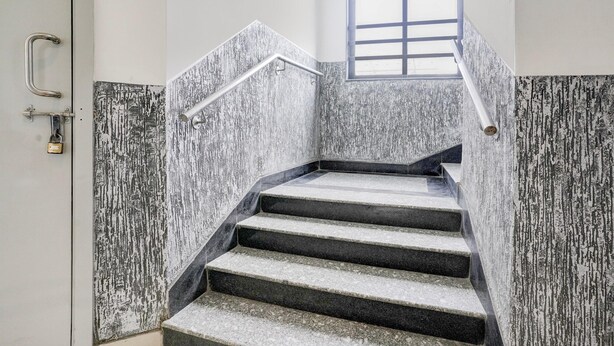 A set of stone steps with metal handrails, a door with a handle and lock, and a window with a grid pattern.