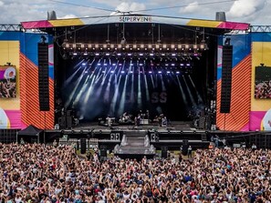 Un grande palco per concerti all'aperto con una folla di spettatori.
