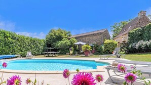 Ein Schwimmbad mit Liegestühlen und einer Terrasse.