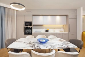 A modern kitchen with built-in appliances, a dining area with a marble table, and a cozy seating arrangement. - Infinity - Four Bedroom Villa, Sleeps 8 (Corfu)