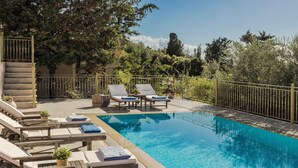 Un espace piscine avec des chaises longues et un escalier.