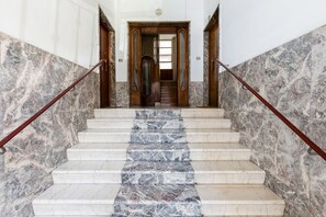 A marble staircase with wooden handrails leading to a doorway. - BDC - The Good One, 3BDR @Nomentano district (Rome)