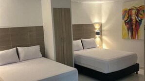 A hotel room with two beds, a wardrobe, and a painting on the wall. - Hotel Brisas del Mar Rodadero (Santa Marta)