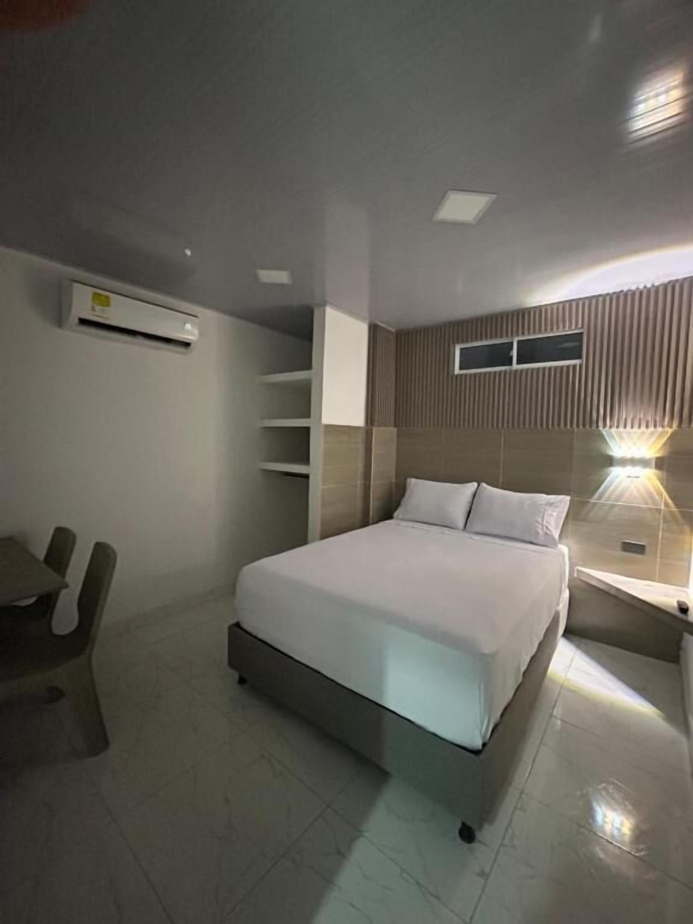 Een moderne hotelkamer met een bed, een bureau en een stoel.