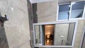 Ein kleines Badezimmer mit Toilette, Waschbecken und Spiegel.