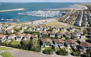 Eine Küstenwohngegend mit Häusern, einem Yachthafen und einem Strand.