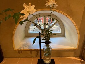 Ein Fensterplatz mit einer Blumenvase und einer Pflanze.