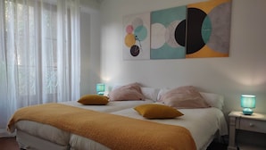 A bedroom with a double bed, two bedside lamps, a large abstract painting, and a window with sheer curtains. - Colorful Room - ASPE (OLORON STE MARIE)