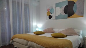 A double bed with a yellow blanket, two bedside tables, and a wall with abstract art. - Colorful Room - ASPE (OLORON STE MARIE)