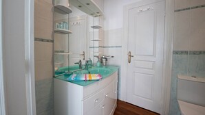 A bathroom with a glass sink, white cabinets, a large mirror, and a white door. - Colorful Room - ASPE (OLORON STE MARIE)