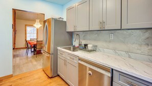A modern kitchen with grey cabinets, a stainless steel refrigerator, and a marble countertop. - Great for Families! Heart of Bethlehem (Bethlehem)