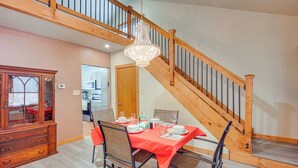 A dining area with a wooden staircase, a chandelier, and a dining table set for six. - Great for Families! Heart of Bethlehem (Bethlehem)