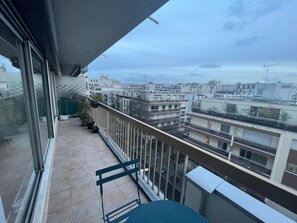 Ein Balkon mit Blick auf eine Stadtansicht, darunter Gebäude und eine Straße.