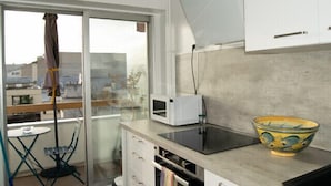 Una cocina con microondas, un tazón y vistas de la ciudad a través de un ventanal.