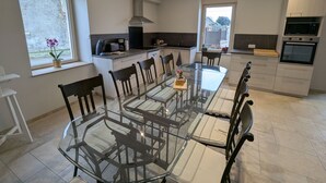 Una cocina moderna con una isla central, electrodomésticos integrados y ventanas amplias.