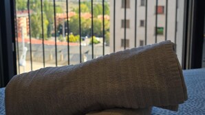 A view from a balcony with a metal railing, overlooking a building with multiple windows and a red roof. - Modern Duplex in the Heart of Jaca for 6 People (Jaca)