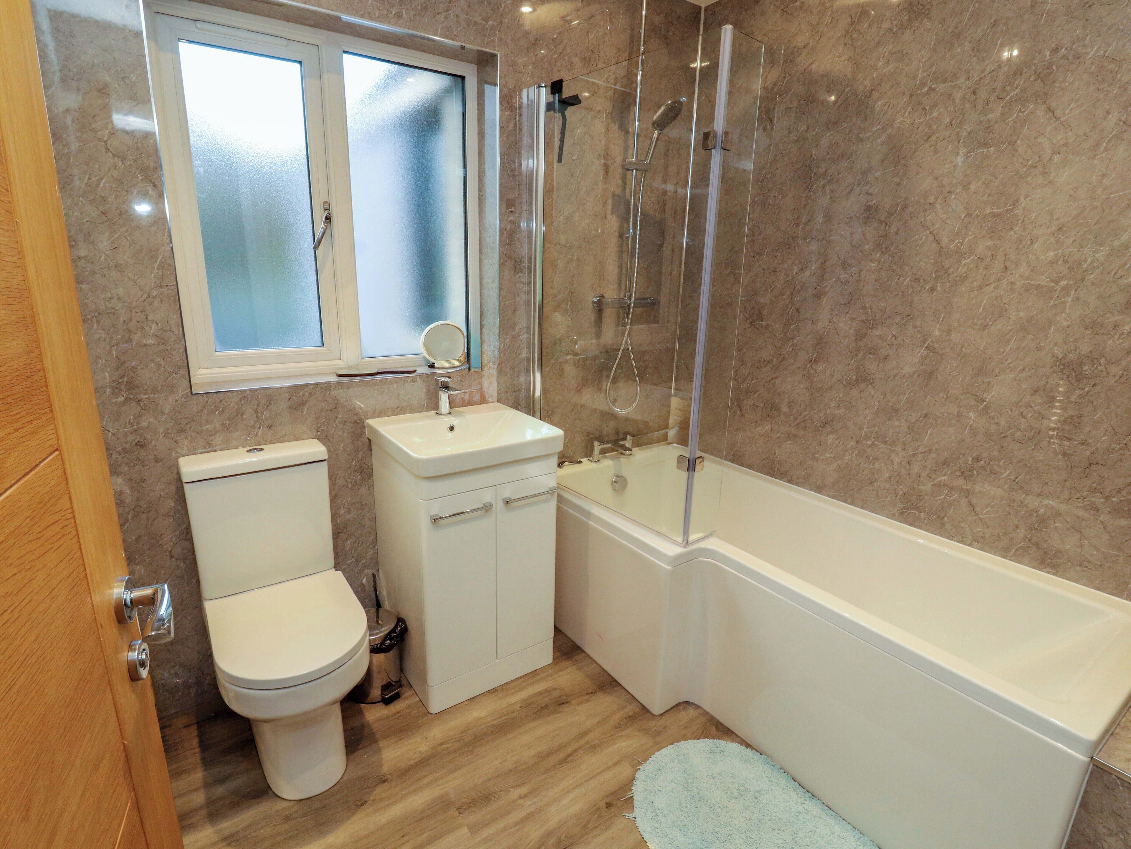 A bathroom with a toilet, sink, and bathtub.