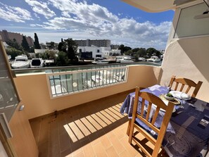 A balcony with a view of a marina, a table with chairs, and a small plant on the table. - Comfortable studio with AC and Wi-Fi, 800m from Santa Margarita beach (Roses)