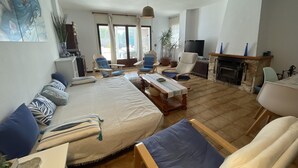 A spacious living room with a large sofa, armchairs, a coffee table, and a fireplace. - Charming Apartment in Puig Rom, Roses with Parking and Terrace, Sleeps 8 (Roses)