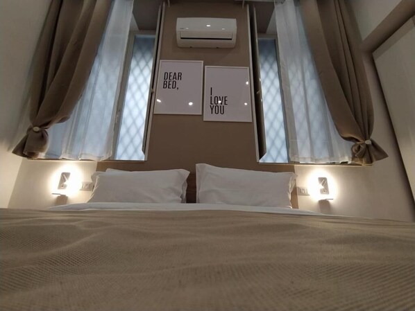 Un dormitorio con una cama, dos lámparas de noche y dos carteles enmarcados en la pared.
