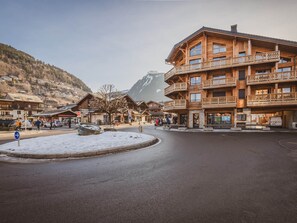 A wooden building with balconies and a snow-covered street. - Modern apartment in Morzine, 6 ppl, Wi-Fi, parking, near slopes (Morzine)