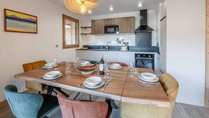 A modern kitchen with wooden cabinets, a built-in microwave, and a black range hood. - Modern apartment in Morzine, 6 ppl, Wi-Fi, parking, near slopes (Morzine)