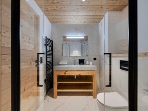 A modern bathroom with a wooden vanity, a glass shower enclosure, and a marble-tiled floor. - Modern 3-bedroom apartment in La Rosière center (Montvalezan-La Rosière)