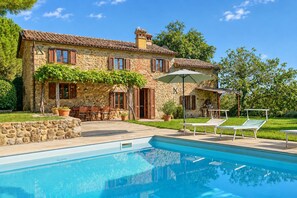 A stone house with a swimming pool, outdoor seating, and a garden. - Adriano House, a hillside home with a stunning pool, offering total relaxation and privacy   (Umbria)