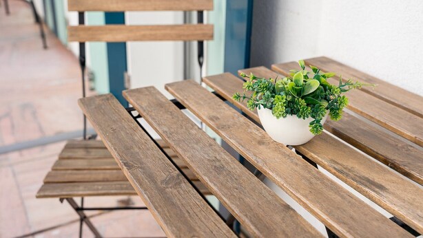 A wooden bench with a potted plant on it. - GuestReady - The Traveler’s Island (Porto)