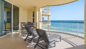 A balcony with a view of the ocean, furnished with chairs and a table. - Beach Colony East 8D (Pensacola)