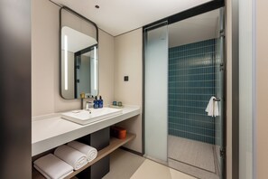 Ein modernes Badezimmer mit Waschbecken, Spiegel und Dusche.