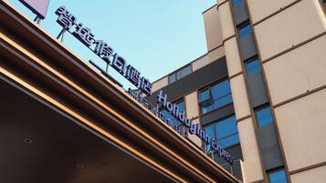 A hotel entrance with a modern design, featuring a glass facade and a sign indicating it is a Holiday Inn Express.