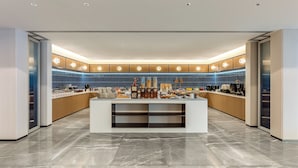 A modern kitchen with a central island, blue backsplash, and a marble floor. - Holiday Inn Express Beijing Lize Business District By Ihg (Beijing)