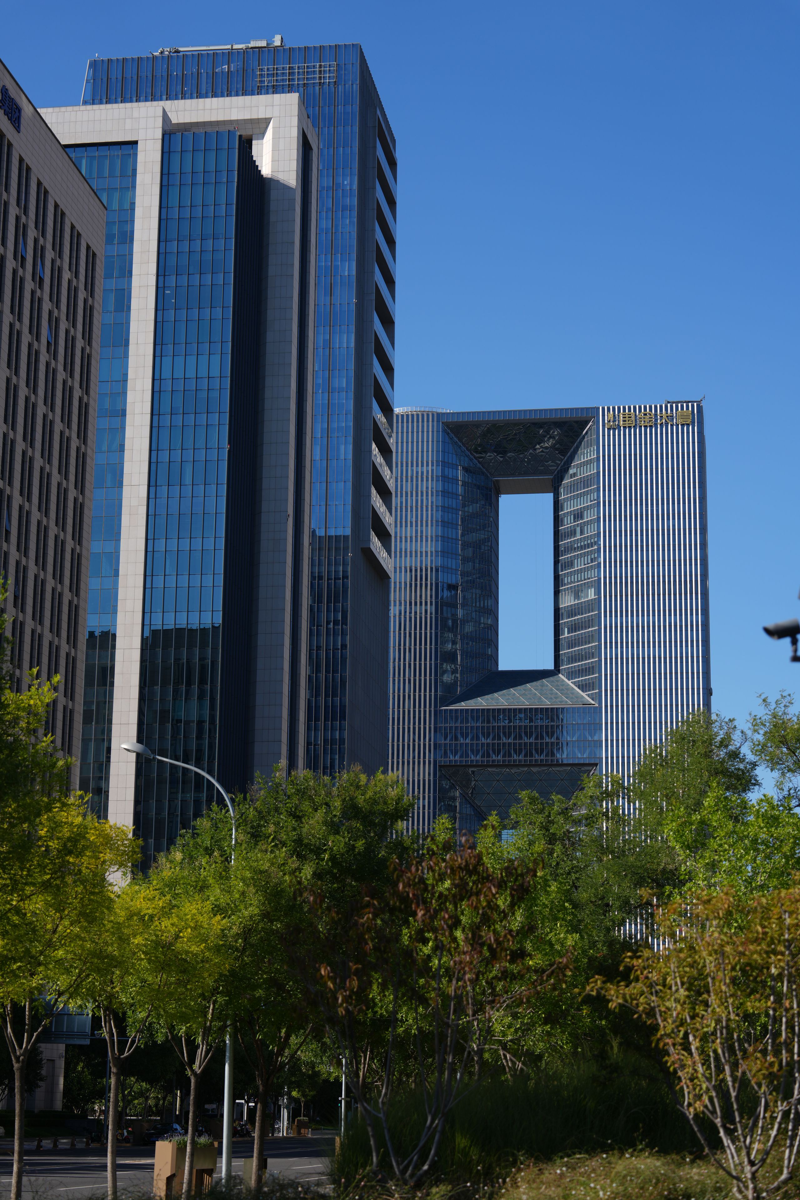 A modern building with a unique architectural design, featuring a large glass facade and a distinctive cut-out section.