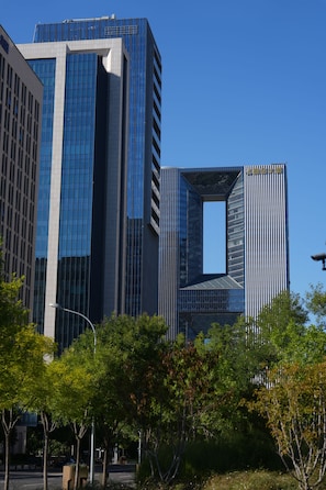 Een modern gebouw met een uniek architectonisch ontwerp, met een grote glazen gevel en een opvallend uitgesneden gedeelte.
