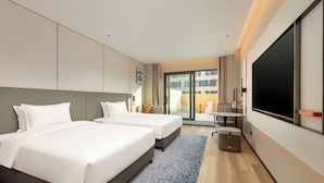 A hotel room with two beds, a TV, a small table, and a view of the outside. - Holiday Inn Express Beijing Lize Business District By Ihg (Beijing)