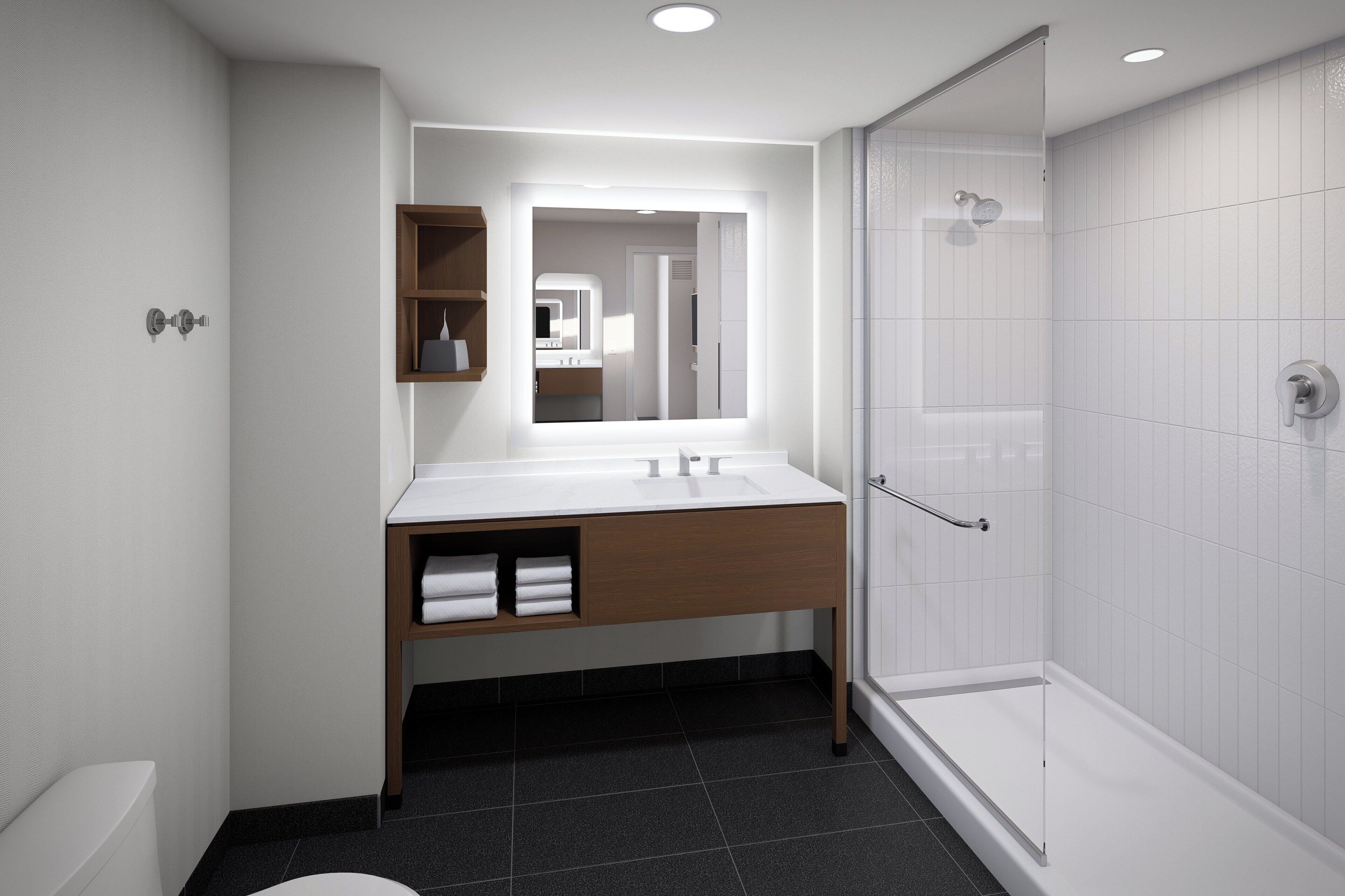 Une salle de bain moderne avec un meuble-lavabo blanc, un miroir, une douche et des toilettes.