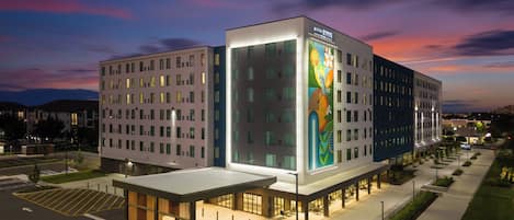 Et hotel i flere etager med moderne design, der har et stort, oplyst skilt og en anlagt gårdhave.