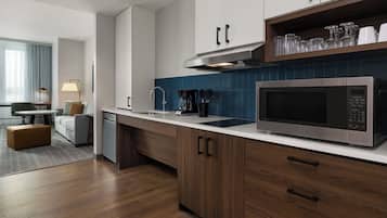 Una cocina moderna con microondas integrado, cafetera y lavaplatos.