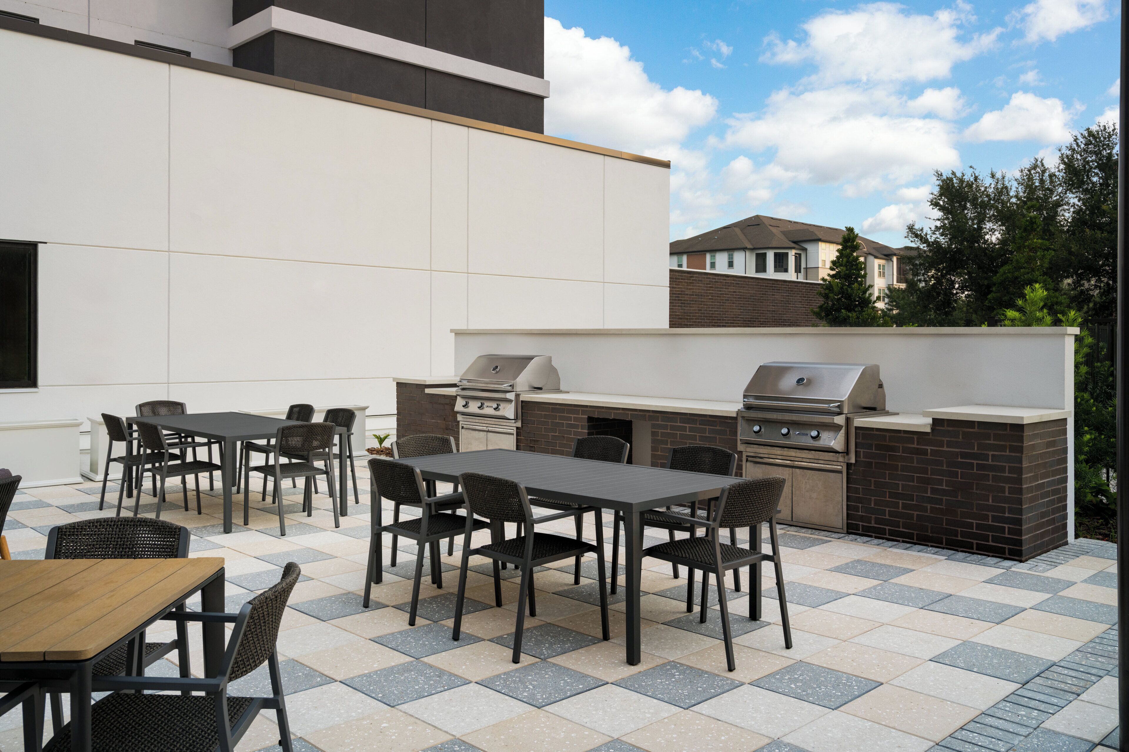 An outdoor patio with a grill and dining area.