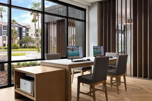 A modern office space with a desk, chairs, and two monitors. - Even Hotel Orlando Universal Blvd By Ihg (Orlando)