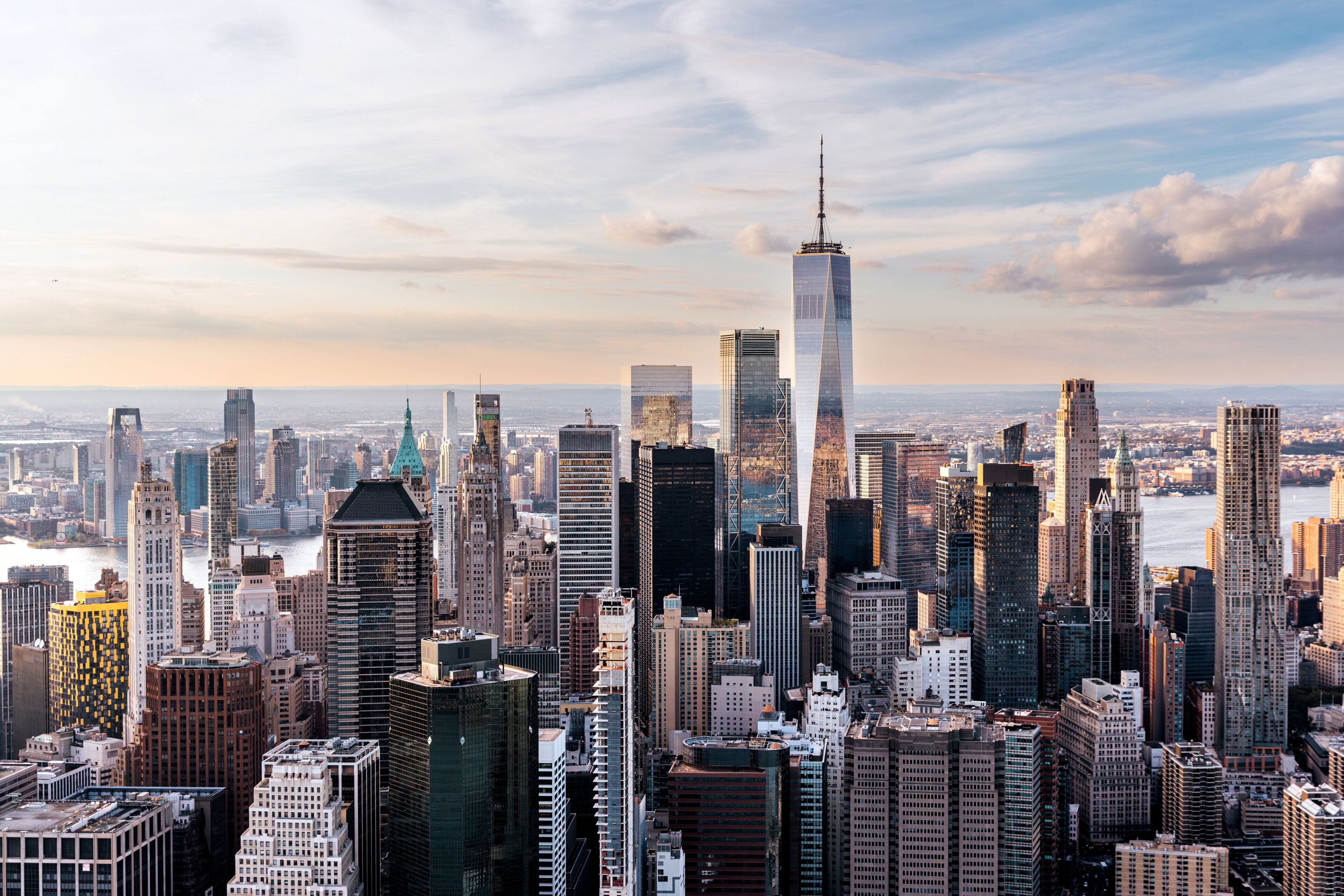 A cityscape with high-rise buildings, including a prominent skyscraper with a pointed top.