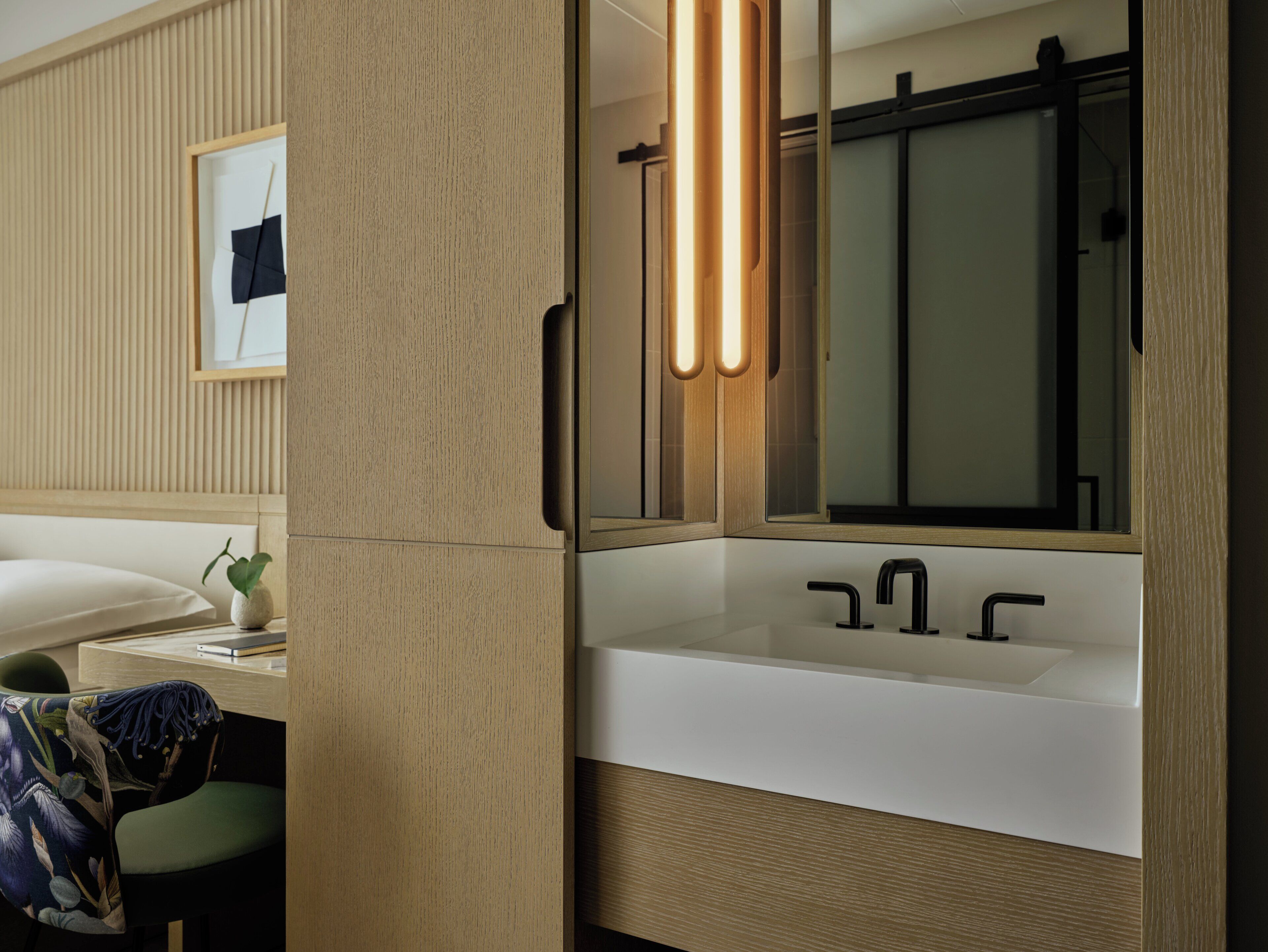 Une salle de bain moderne avec un grand miroir, un lavabo blanc et un meuble-lavabo en bois.