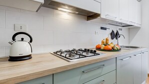 A modern kitchen with a gas stove, kettle, and a variety of vegetables on the counter. - BDC - Zenit 1BDR @Vaticano (Rome)