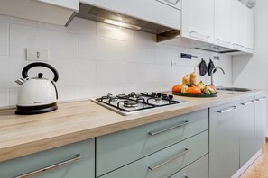 A modern kitchen with a gas stove, kettle, and a variety of vegetables on the counter. - BDC - Zenit 1BDR @Vaticano (Rome)