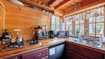 Een koffiezetapparaat/waterkoker, kookgerei, borden en bestek