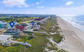 A coastal property with multiple buildings, a beach, and a pier extending into the ocean. - 1 Bedroom Oceanfront - Walk right out to the beach! (Ocean Isle Beach)
