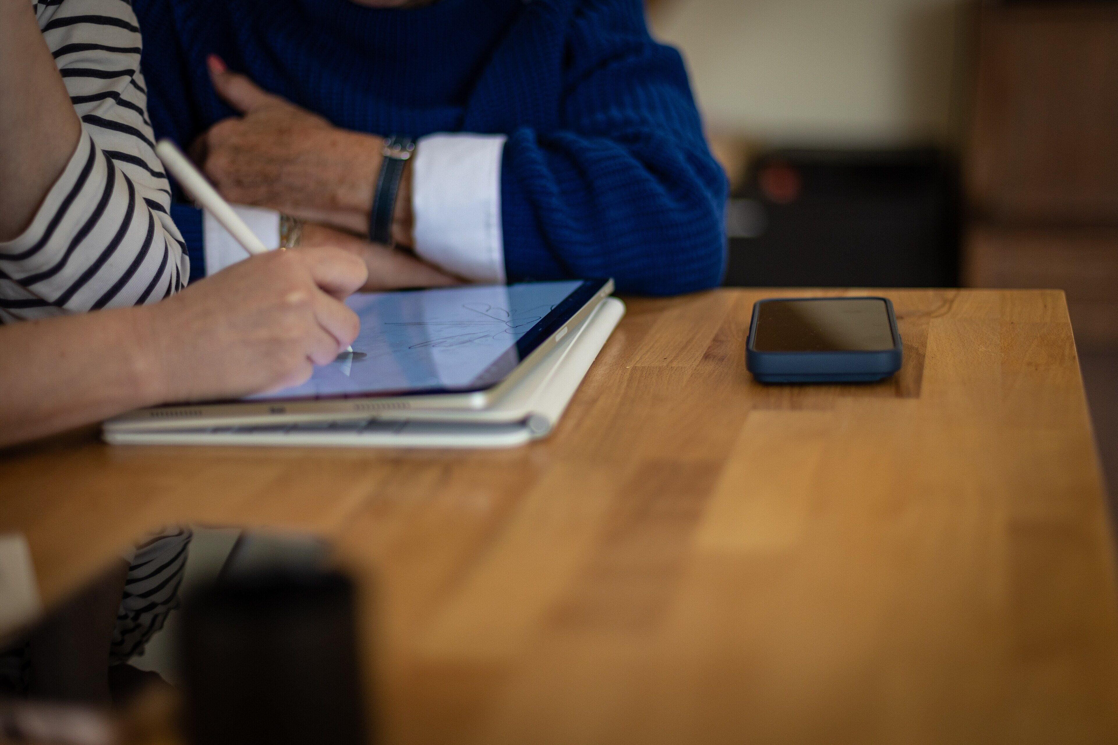 Un tavolo di legno con uno smartphone e un tablet.