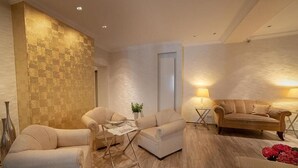 A modern living room with a sofa set, a coffee table, and a lamp.